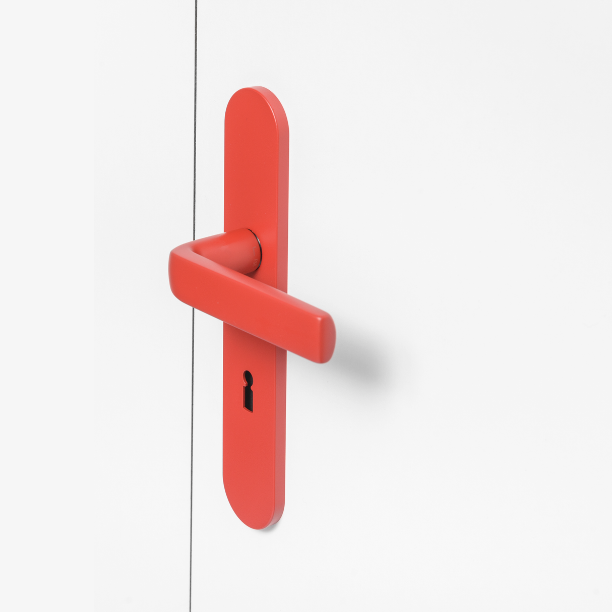 FSB 1267 Türdrücker mit Langschild in Les Couleurs® Le Corbusier® Rouge Vermillon 31 auf weißer Tür, Seitenansicht.