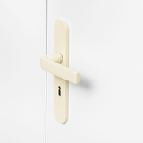 FSB 1267 Türdrücker mit Langschild in Les Couleurs® Le Corbusier® Blanc auf weißer Tür, Seitenansicht.