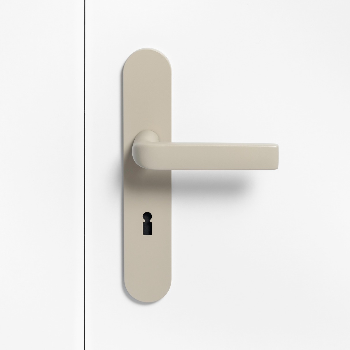 FSB 1267 Türdrücker mit Langschild in Les Couleurs® Le Corbusier® Ombre Naturelle Clair auf weißer Tür, Frontansicht.