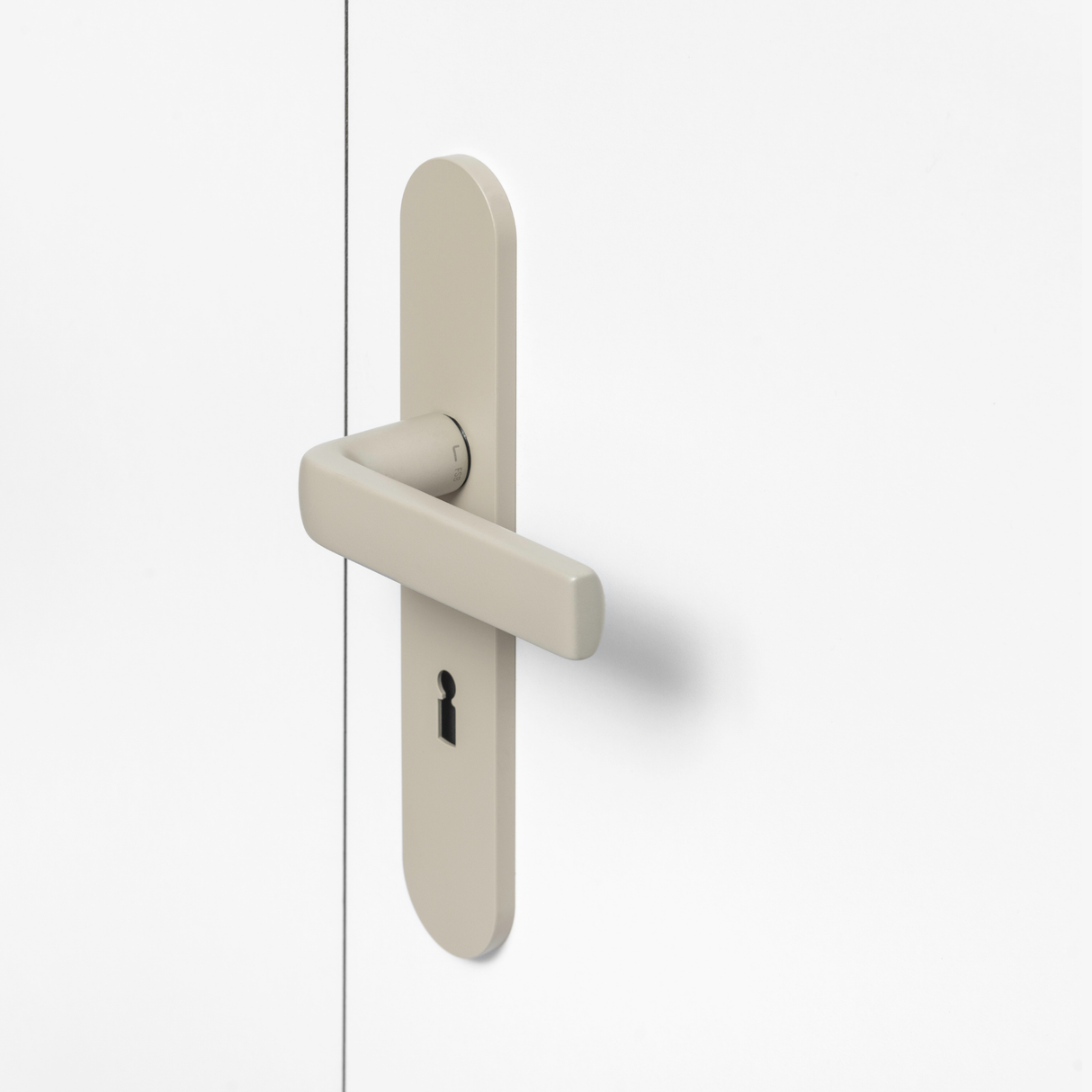 FSB 1267 Türdrücker mit Langschild in Les Couleurs® Le Corbusier® Ombre Naturelle Clair auf weißer Tür, Seitenansicht.