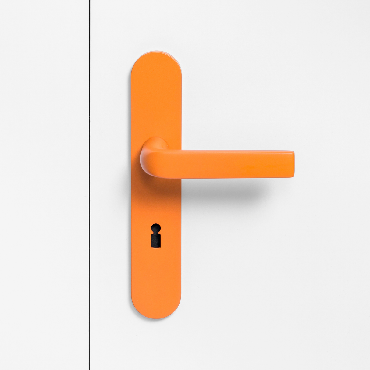 FSB 1267 Türdrücker mit Langschild in Les Couleurs® Le Corbusier® Orange auf weißer Tür, Frontansicht.