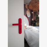 Rote FSB 1267 Langschildgarnitur in Les Couleurs Le Corbusier rouge vermillon 31 an weißer Tür im Schlafzimmer.