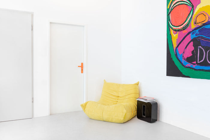 Innenraum im Projekt Büro Ozmoze, Berlin, mit weißer Tür und FSB 1267 Drückergarnitur in Les Couleurs® Le Corbusier® Orange; gelber Sessel und farbiges Wandbild im Raum, Foto: Philipp Jester.
