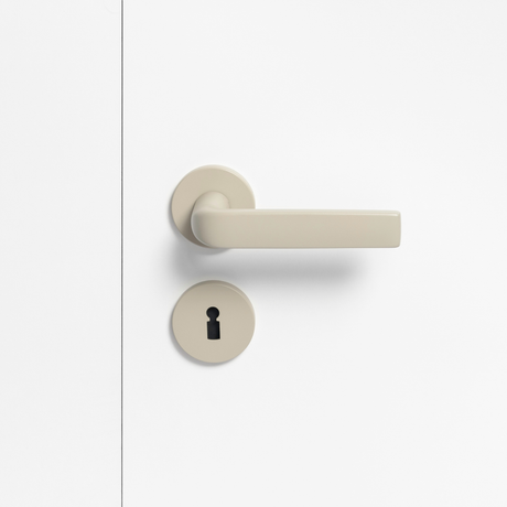 FSB 1267 Türdrücker mit Rundrosetten in Les Couleurs® Le Corbusier® Ombre Naturelle Clair auf weißer Tür, Frontansicht.