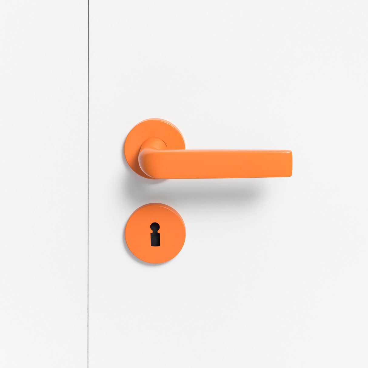 FSB 1267 Türdrücker mit Rundrosetten in Les Couleurs® Le Corbusier® Orange auf weißer Tür, Frontansicht.