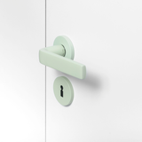 FSB 1267 Türdrücker mit Rundrosetten in Les Couleurs® Le Corbusier® Vert Anglais Pâle auf weißer Tür, Seitenansicht.
